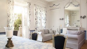 Una habitación con una mesa de comedor, dos sofás, un espejo grande y vistas al exterior.