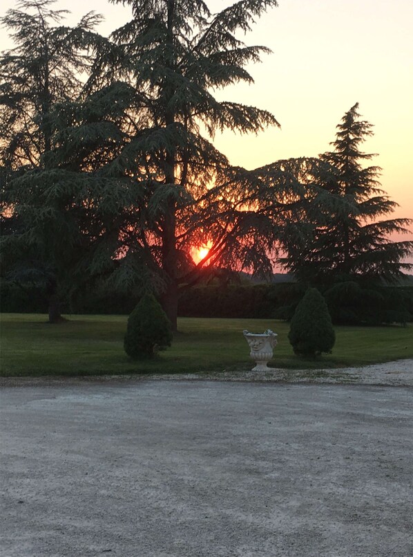 A sunset view with trees and a fountain in a park. - Domaine De Pouzelande B&B (Sanilhac)