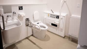 A modern bathroom with a white toilet, a sink, and a bidet.
