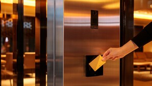 Una mano insertando una tarjeta llave en el lector de una cabina de ascensor.
