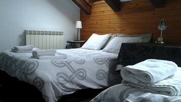 A bedroom with a bed, pillows, a bedside table, and a lamp.