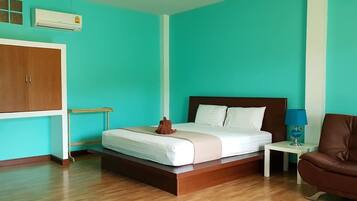 A bedroom with a bed, a brown leather chair, a nightstand, and a wardrobe.