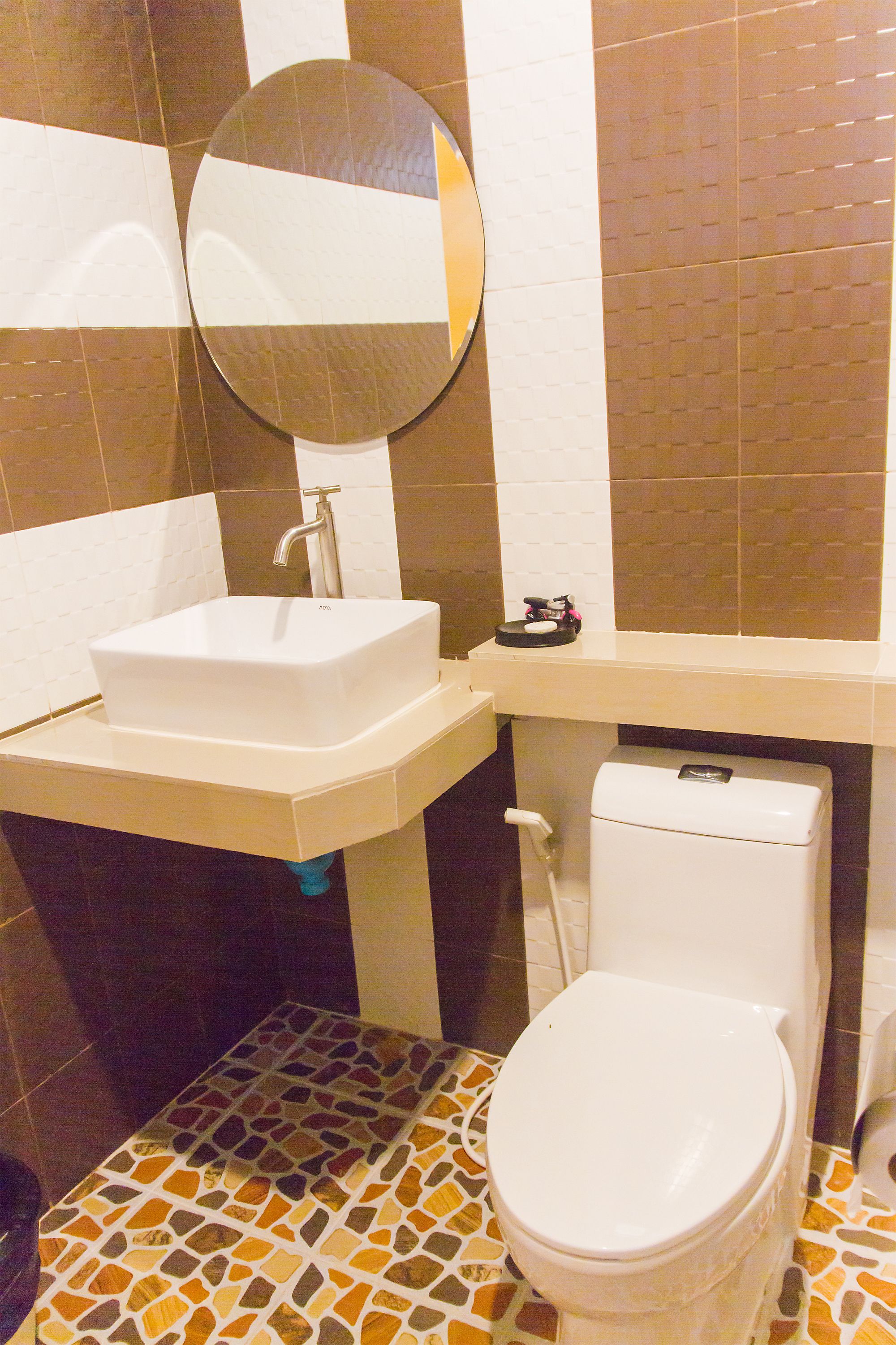 Un baño con lavamanos blanco, espejo y retrete.