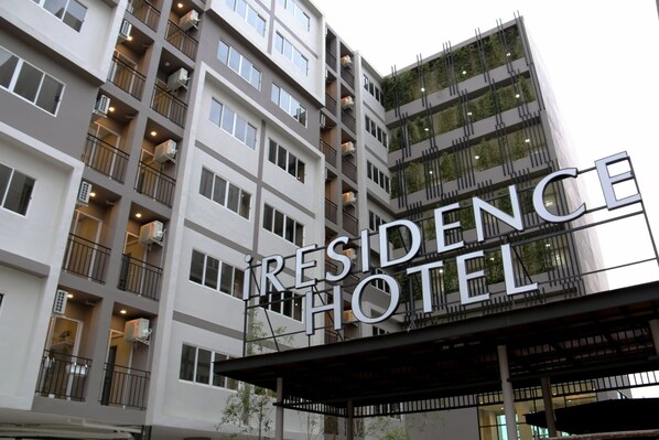 Un hotel de varios pisos con balcones y unidades de aire acondicionado.