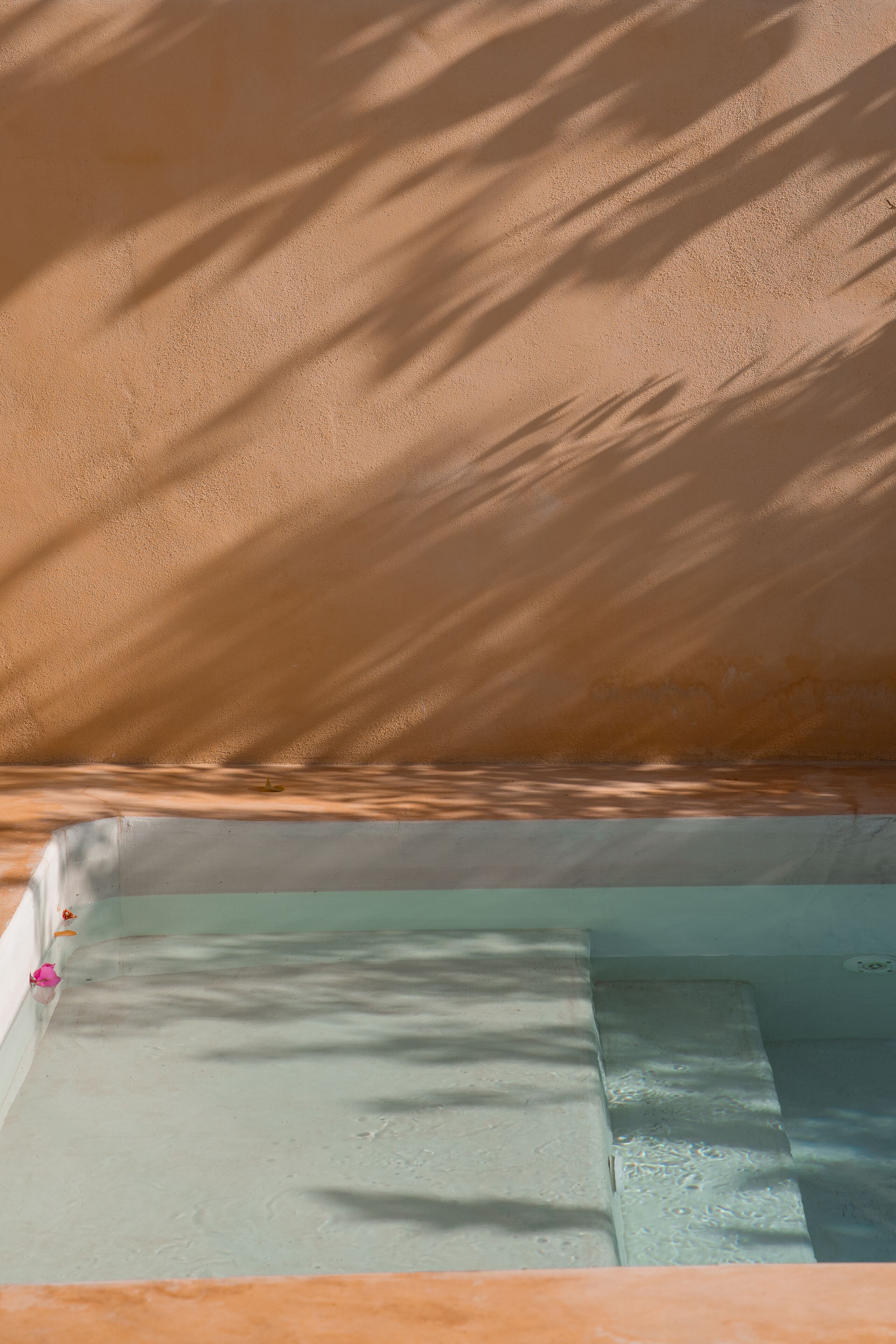 A pool area with a sandy floor and a clear water section.