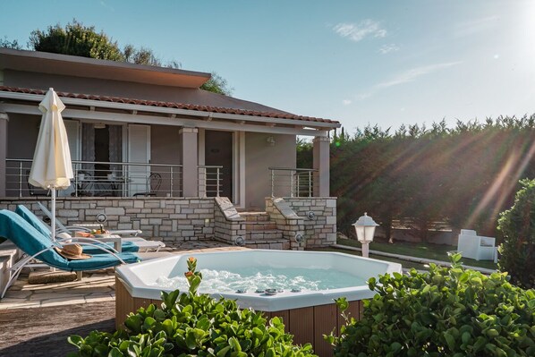 Relax by the pool with a hot tub, lounge chairs, and a fruit basket.