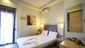 Una habitació d'hotel amb llit, taula de nit i mirall.