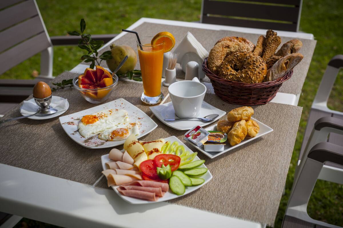 A table set with breakfast items including eggs, bread, and fruit.