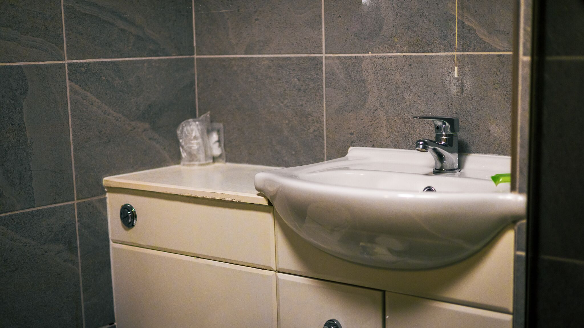 A bathroom with a white sink, a mirror, and a cabinet.