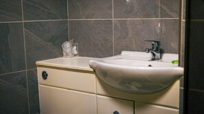 A bathroom with a white sink, a mirror, and a cabinet.
