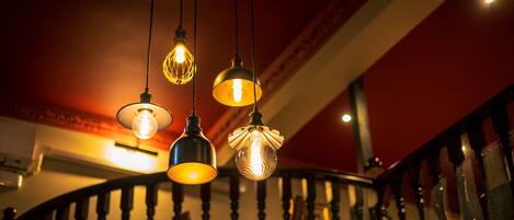 A staircase with a wooden railing and hanging light fixtures.