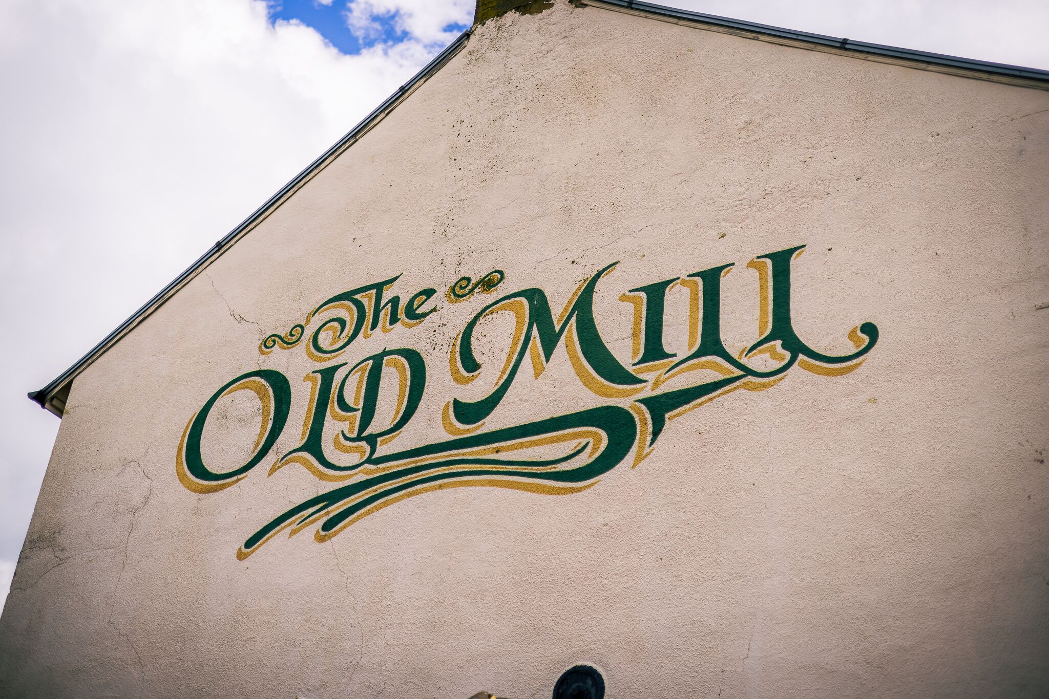 A building with a sign that reads "The Co Old Mill".