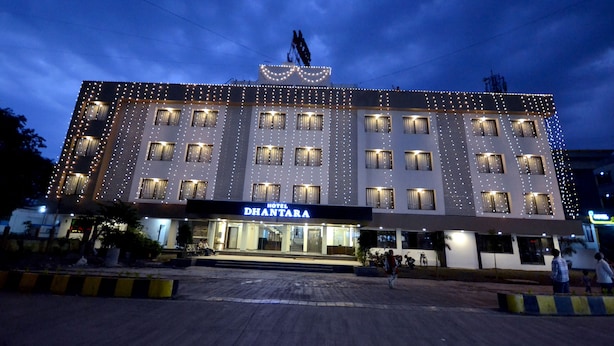 A hotel with a modern facade, multiple balconies, and a well-lit entrance. - Hotel Dhantara (Rahata)