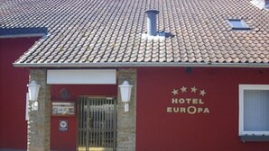 A red building with a tiled roof and a sign that reads "HOTEL EUROPA".