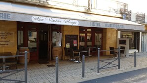 Un hôtel doté d’une terrasse et d’une enseigne indiquant « Le Victor Hugo ».