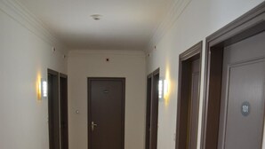 Un couloir doté d’un plancher en bois, de murs blancs et de portes numérotées 101 et 102.
