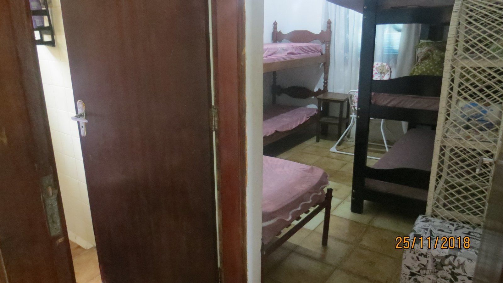Un dormitorio con literas, una puerta de madera y una mesita.