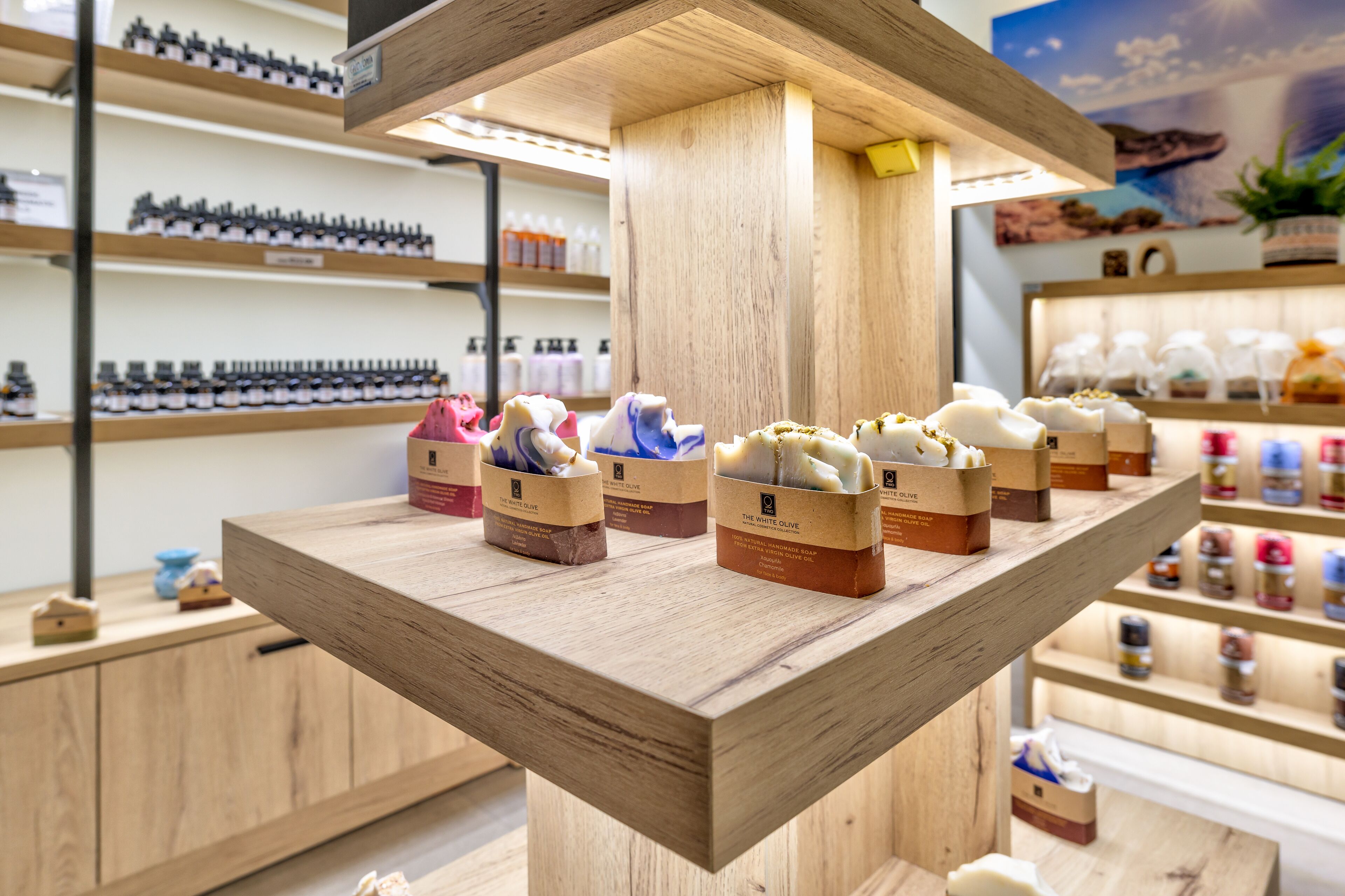 A wooden display shelf with various products, including jars and boxes, in a store setting.