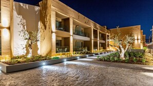 A modern building with multiple balconies and a paved walkway. - White Olive Elite Laganas - All Inclusive (Zakynthos)