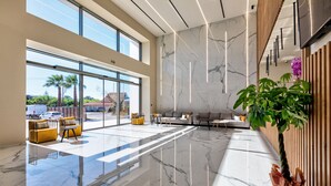 A spacious lobby with a marble floor, large windows, and a potted plant. - White Olive Elite Laganas - All Inclusive (Zakynthos)