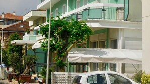 Un hotel de varios pisos con balcones y un cartel que dice 'HOTEL DOLORES'.