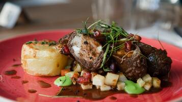 Un plato de comida con carne, papas y vegetales verdes.