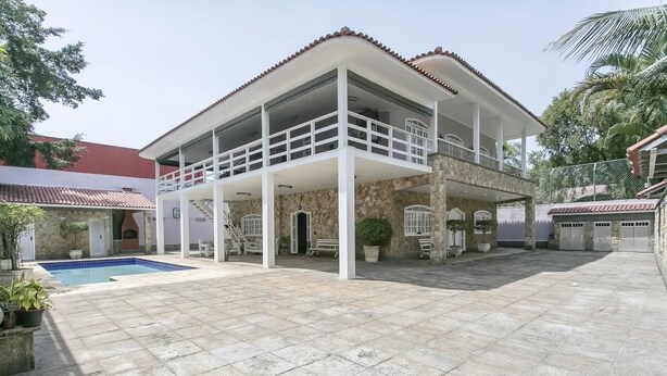 A two-story house with a balcony, a swimming pool, and a stone facade. - Alameda dos Eucalipitos (Rio de Janeiro)