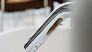 Un baño moderno con un grifo cromado y un lavamanos blanco.