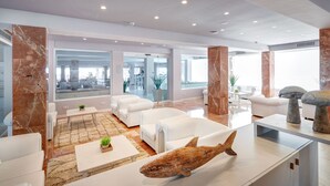 A modern living room with white furniture, a large window, and a decorative whale sculpture. - Protur Bonamar Hotel - Adults Only (Son Servera)