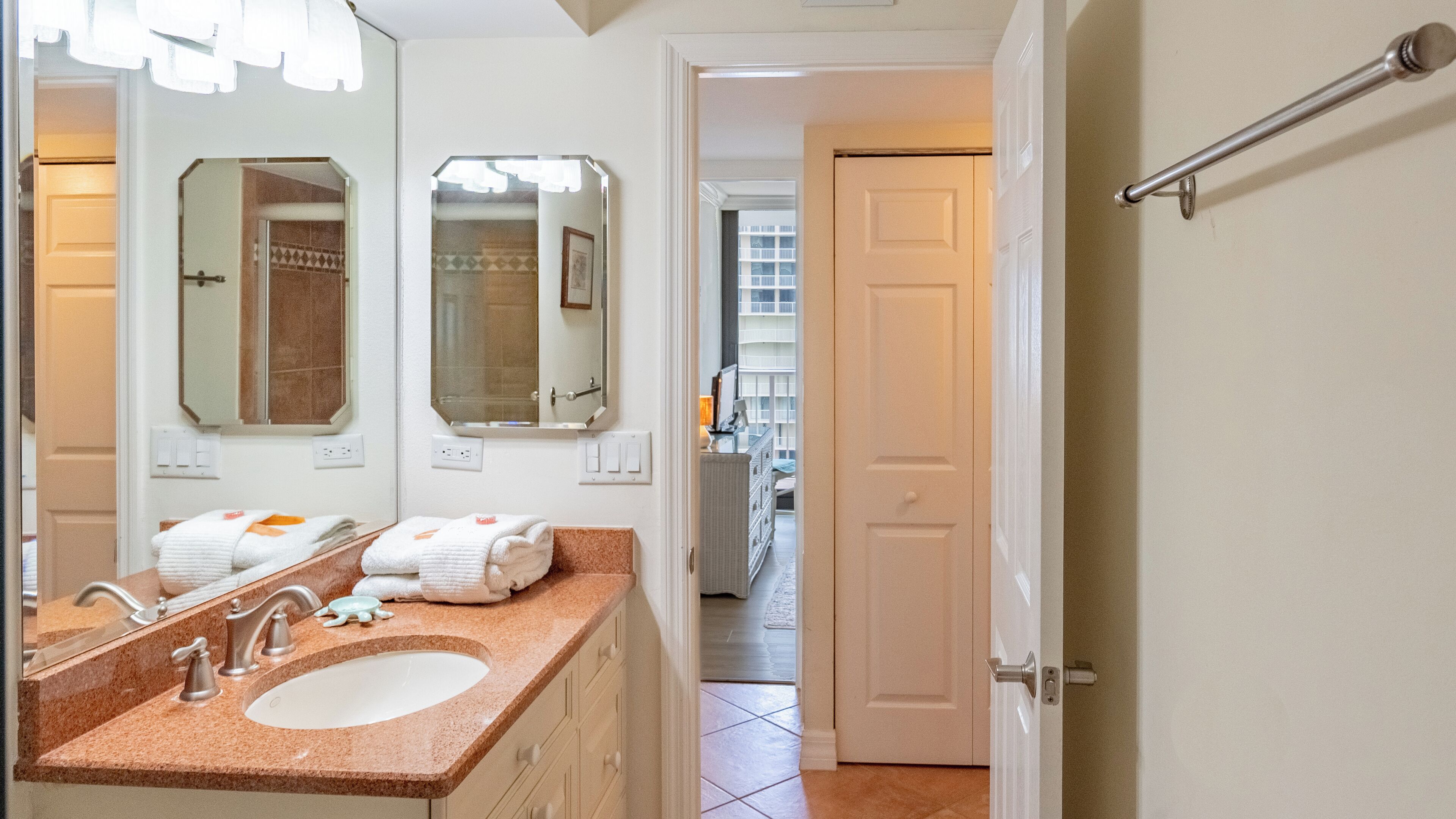 Une salle de bain avec un lavabo, des miroirs et des serviettes.