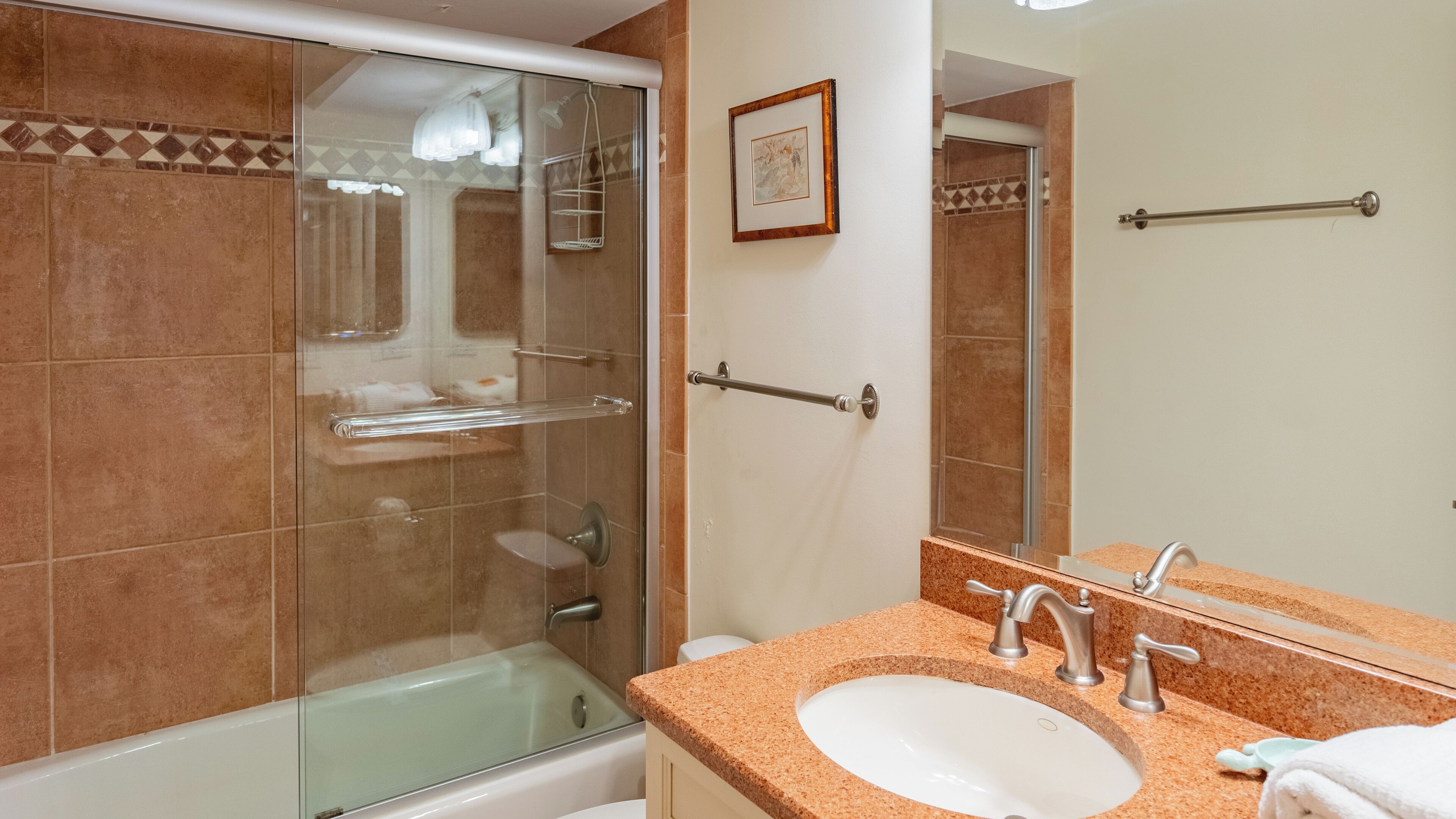 Une salle de bain avec une douche à parois de verre, une baignoire, un lavabo avec un miroir et un porte-serviettes.