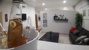 A modern living room with a white coffee table, a black sofa with cushions, a glass bottle on the table, and a wall with motivational quotes. - New historic center apartment (1) 200 meters from the boardwalk  (Zona Comercial)