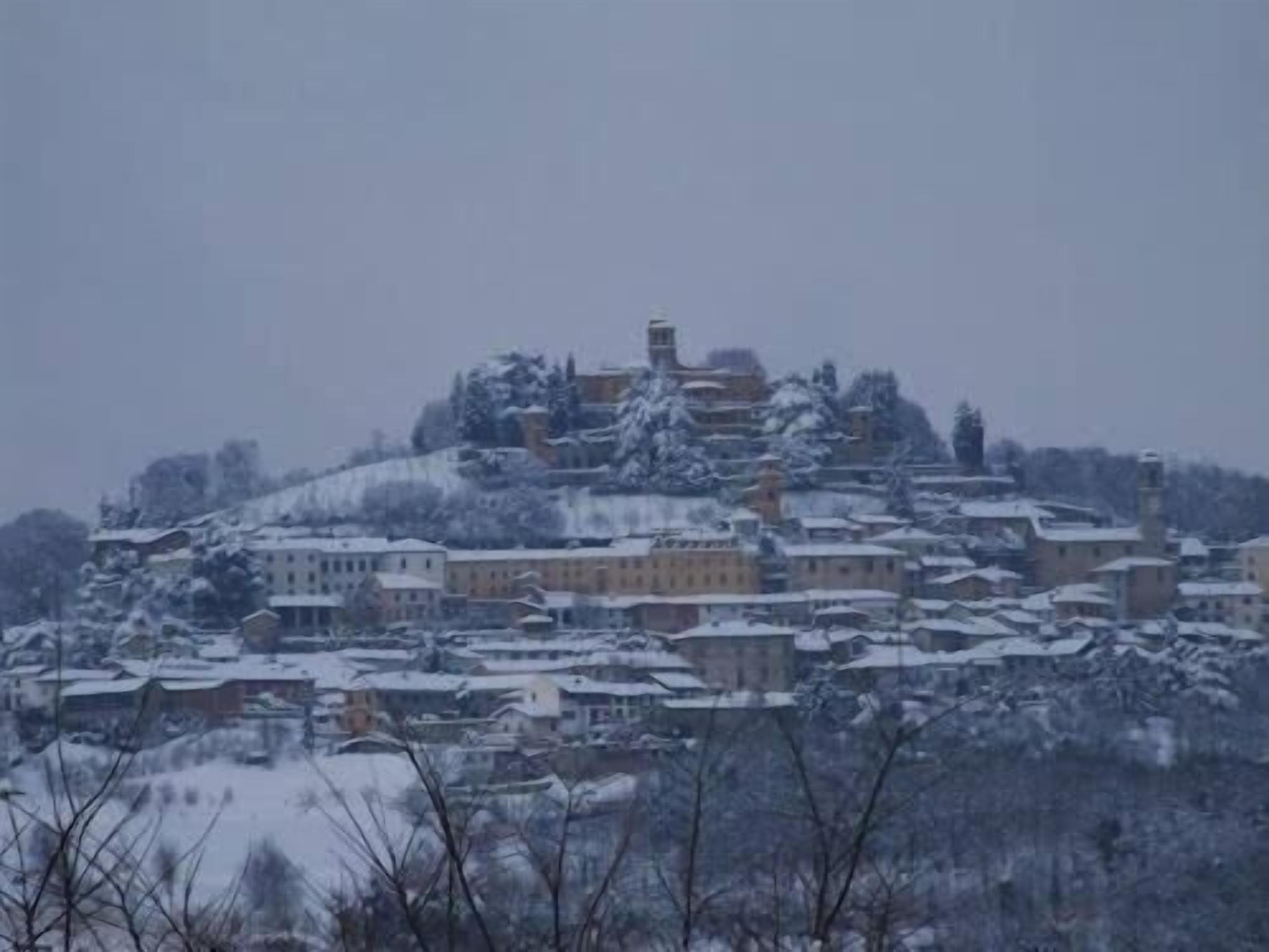 A snow-covered town with historic buildings, including a prominent tower.
