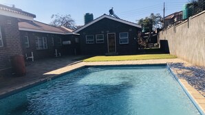 Une piscine rectangulaire à l’eau d’un bleu limpide, entourée d’une terrasse dallée.
