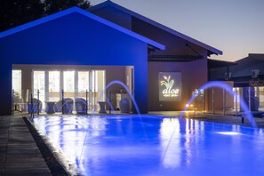 A modern building with a pool area, featuring a sign that reads "aloe - day spa". - Palm Park Hotel (Lephalale)