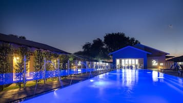 Una piscina al aire libre, sillones reclinables de piscina