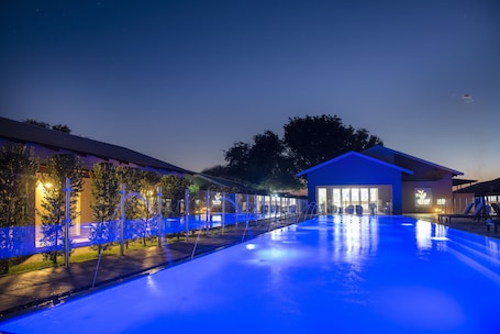 Una piscina al aire libre, sillones reclinables de piscina