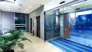 A modern lobby with glass walls, a tiled floor, and a potted plant. - ibis budget Medellín Itagüí Metro (Itagüí)
