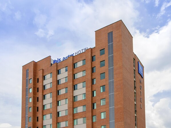 A multi-story hotel building with a prominent sign reading 'ihis bucket hotel.' - ibis budget Medellín Itagüí Metro (Itagüí)