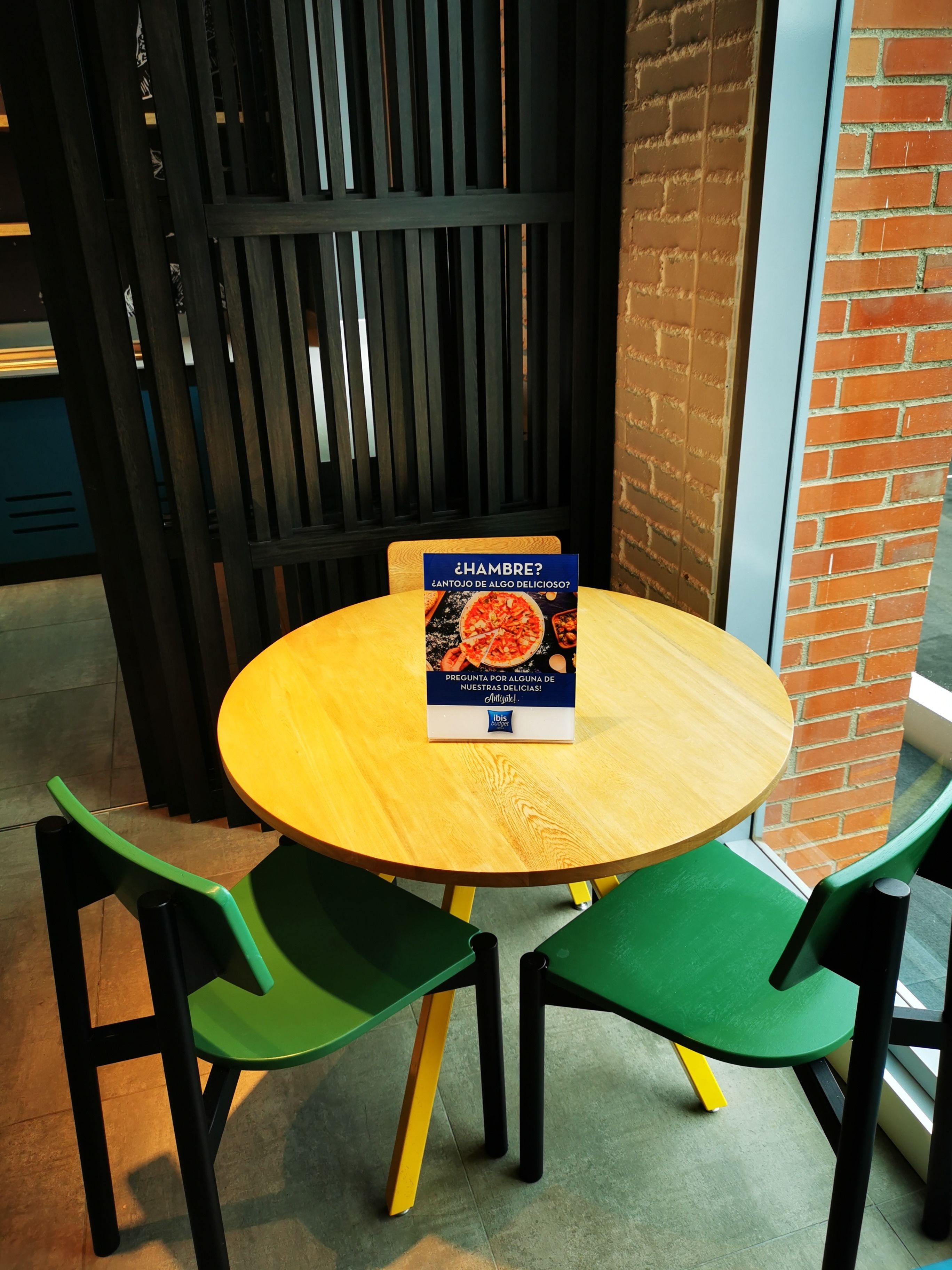 A round wooden table with a book titled "¿Hambre?" placed on it.