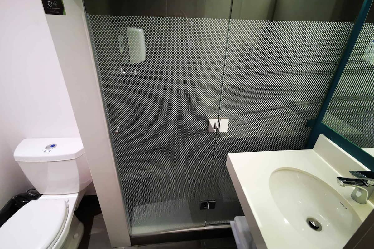 A bathroom with a toilet, a sink, and a shower enclosure.