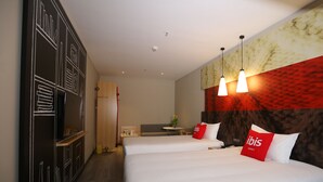 A hotel room with two beds, a desk, and a small seating area. - Ibis Haikou Injoy Plaza Hotel (Haikou)