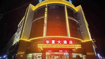 A hotel with a prominent entrance, signage, and a statue in front.