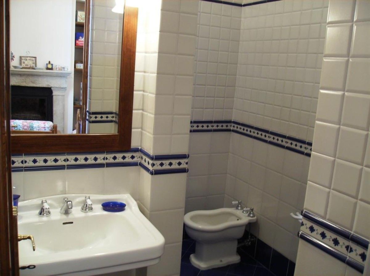 A bathroom with a sink, bidet, and a mirror.