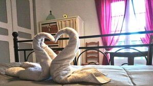 Un lit décoré avec des serviettes disposées en forme de cœur.