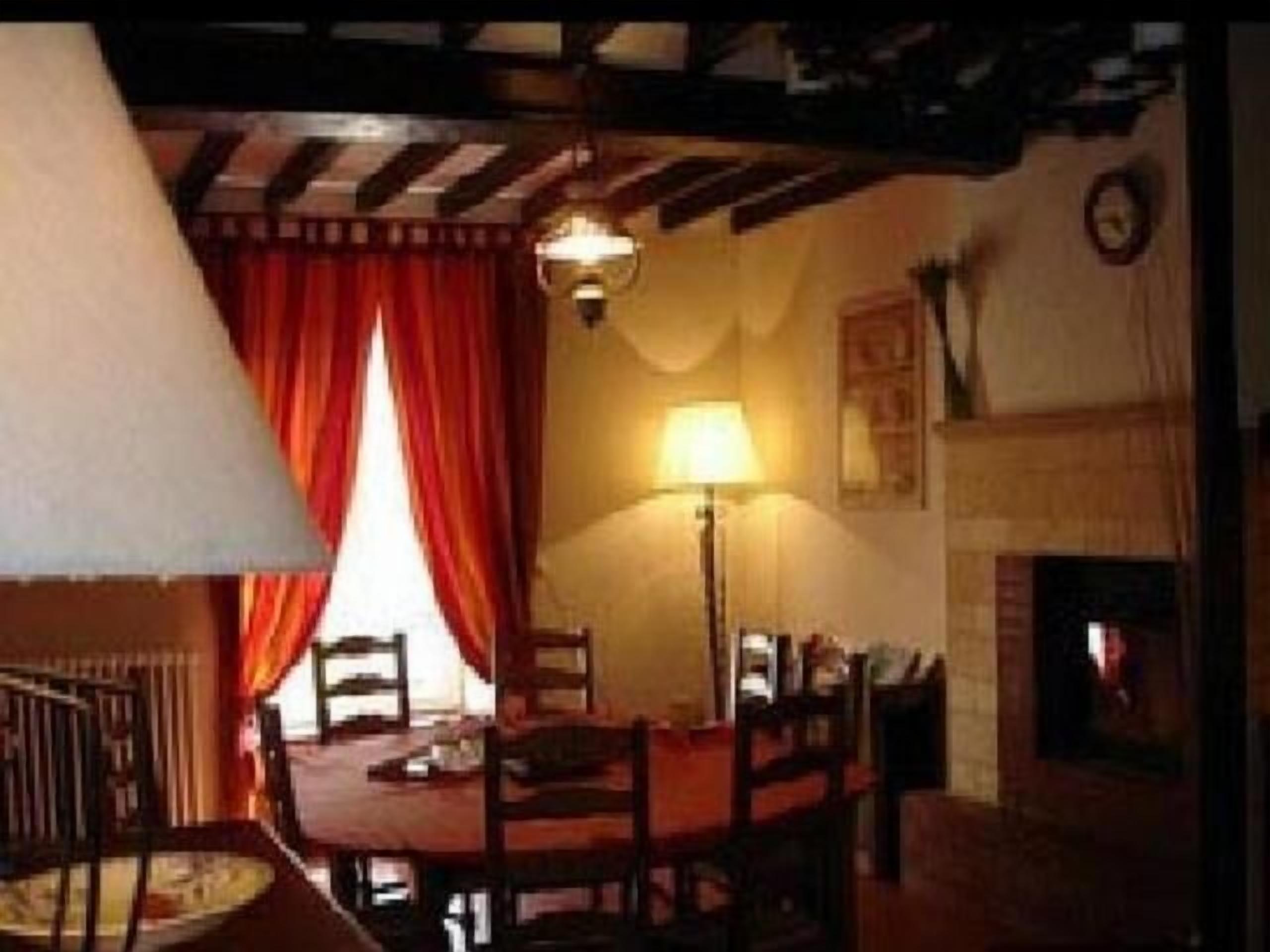 Une pièce chaleureuse avec une cheminée, une table à manger et des chaises.