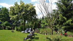 A garden with a lawn, a bench, and a tree. - Landhotel Kertscher-Hof (Nobitz)