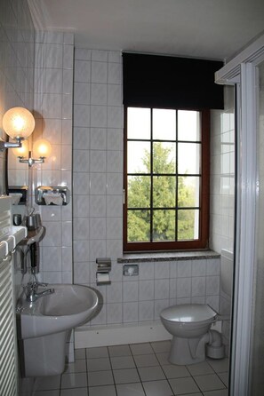 A bathroom with a window, a sink, a bidet, and a toilet. - Landhotel Kertscher-Hof (Nobitz)