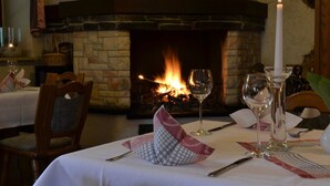 A dining table set for two with a fireplace in the background. - Landhotel Kertscher-Hof (Nobitz)
