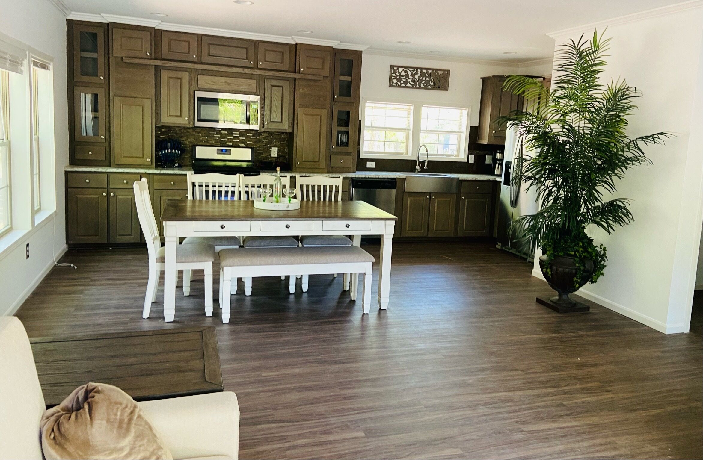 Una cocina moderna con armarios de madera, una isla central y una mesa de comedor con sillas.